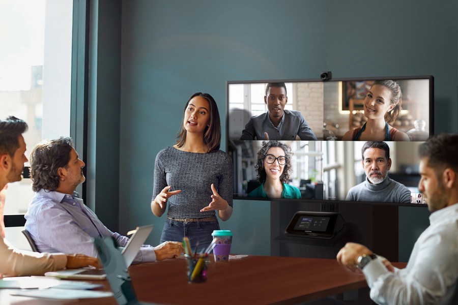 A group of people conducting a video call at a conference room.