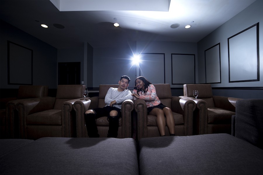 Two people enjoying a movie in a home theater. 