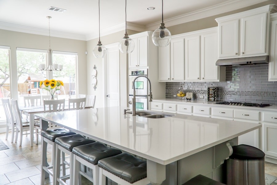 A beautifully lit dining and kitchen area featuring both natural light and fixtures.