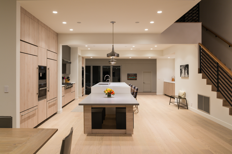 A large, open-concept, contemporary kitchen with recessed and pendant lighting.