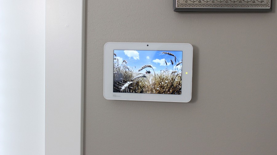  A modern security system control panel is pictured on a wall. 